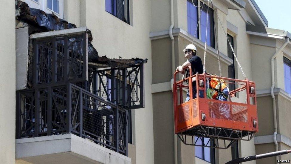 Workmen examine the damage at the scene of a 4th-story apartment building balcony collapse in Berkeley, California June 16, 2015.