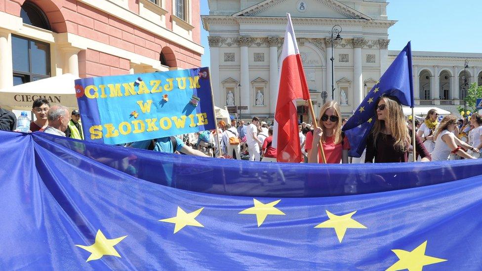 Young people wave Polish and European Union flags during the yearly Schumann Parade supporting EU ideas, in Warsaw, Poland, Saturday, May 7, 2016.