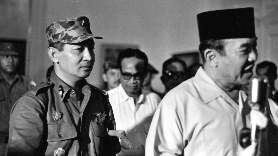 President Sukarno (R) of Indonesia walks with the Major General Suharto (L)