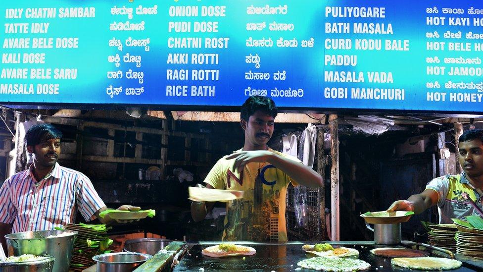 India cooks prepare the popular South Indian 'dosa' at a roadside stall in Food Street in Bangalore on October 24, 2014.