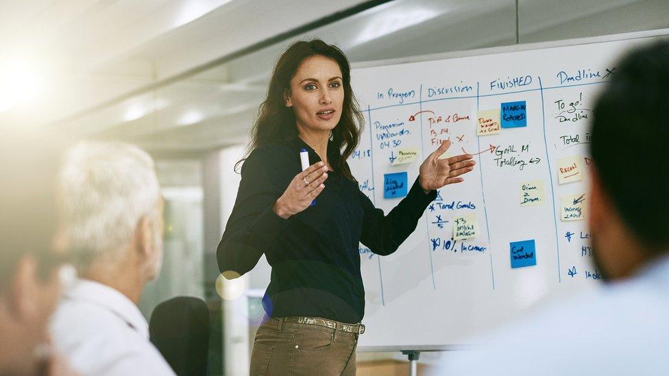 Woman teaching using whiteboard