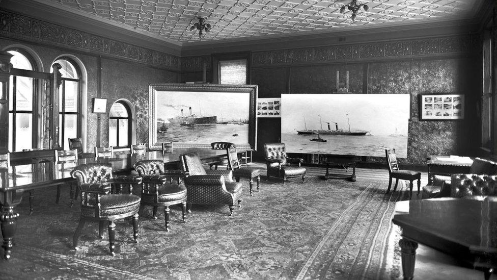 A black and white image shows the presentation room.