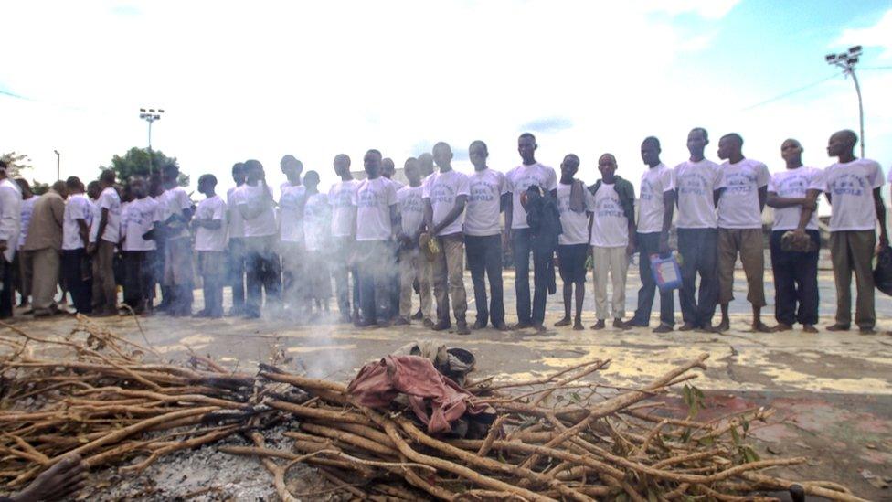 Militia fighters lined up in front of altar at the stadium in Kananga