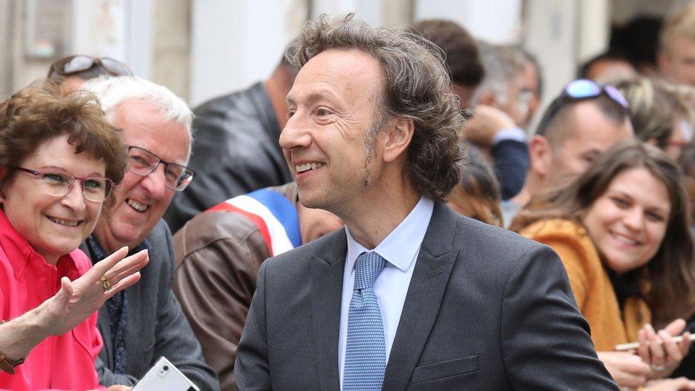 Stephane Bern is pictured surrounded by smiling members of the public in June, near Rochefort, western France.