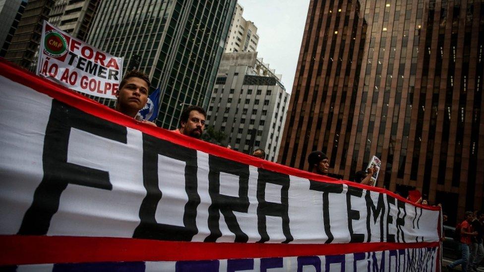 "Temer out," reads the banner held at a march in Sao Paulo