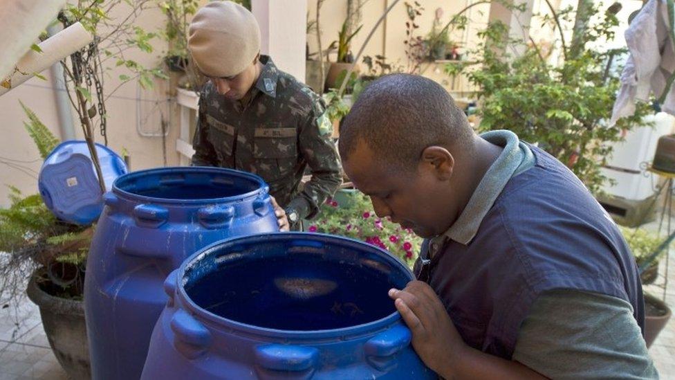 A Health Ministry agent (right) and a soldier look for places suitable for reproduction of the insects during an operation to fight the Aedes aegypti mosquito in Sao Paulo (03 February 2016)