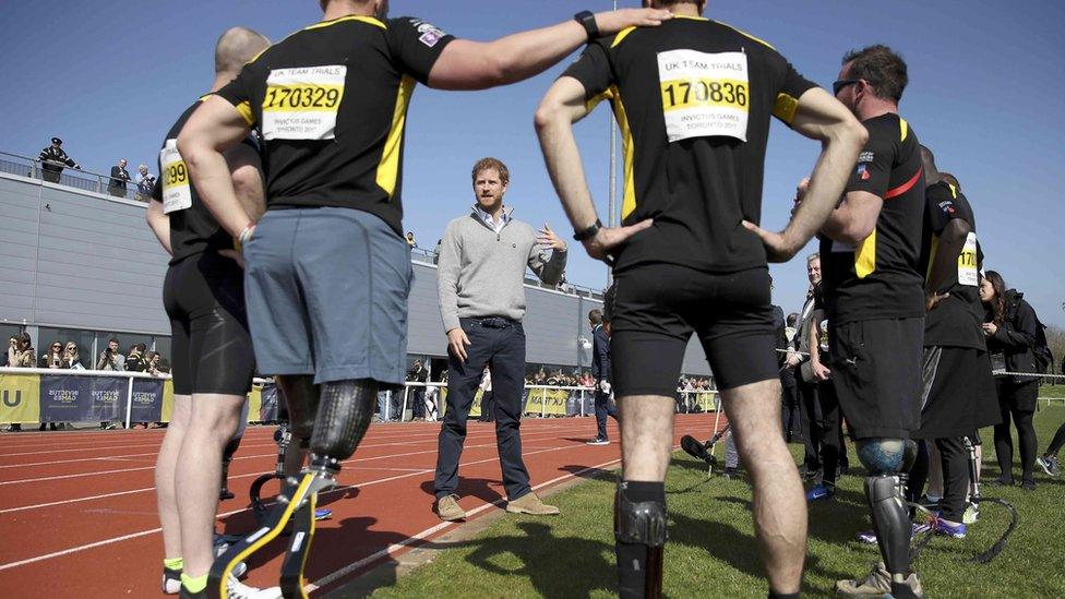 Prince Harry speaks to competitors on the track