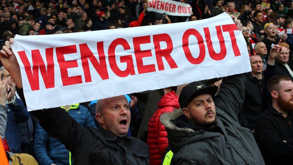 Fans showing a banner saying Wenger out