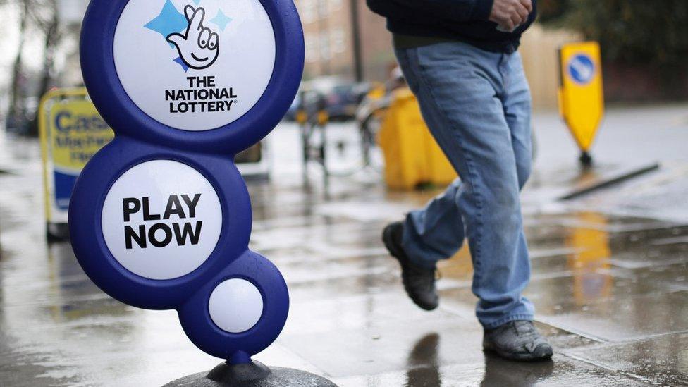 Person walks past lottery sign