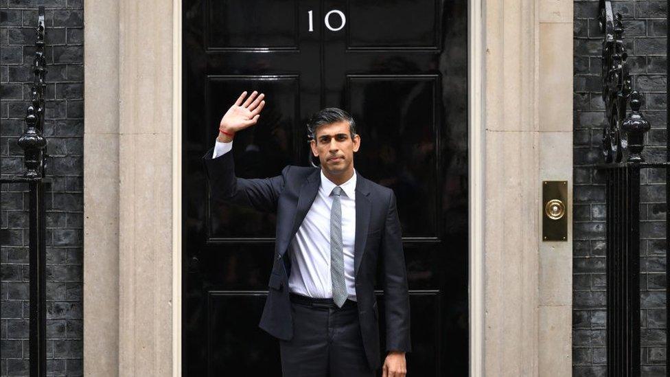 British Prime Minister Rishi Sunak waves to members of the media after taking office outside Number 10 in Downing Street