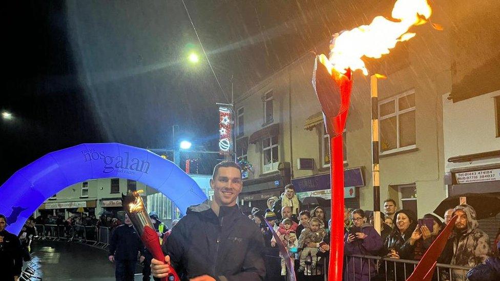 George North holding a torch