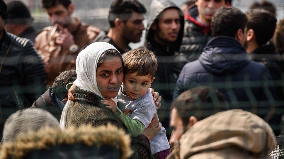 Migrants wait at a Turkish coast guard station at the Dikili district in Izmir, on March 20, 2016, after they were caught while trying to reach the Greek island of Lesbos