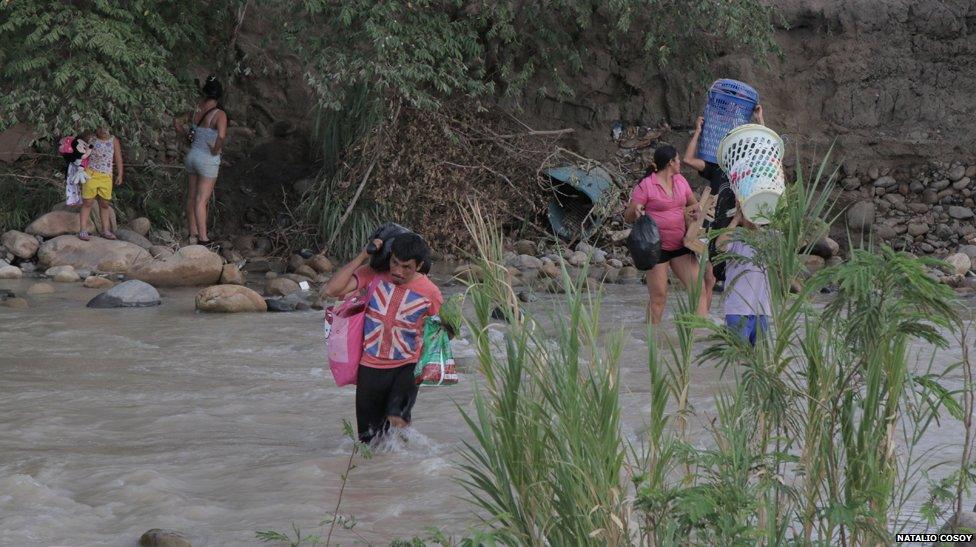 Colombians living in Venezuela cross into Colombia by crossing the Tachira river