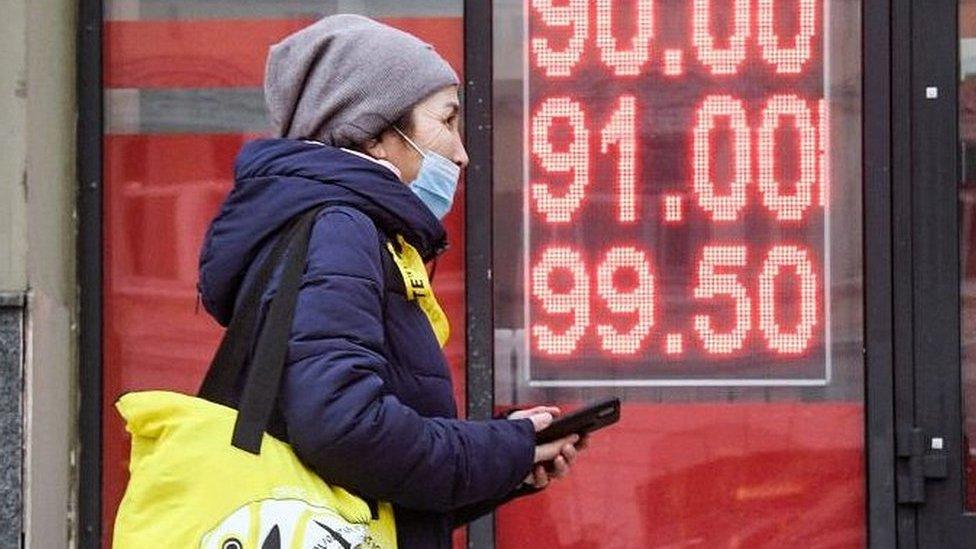 A woman walks by a currency exchange in Moscow