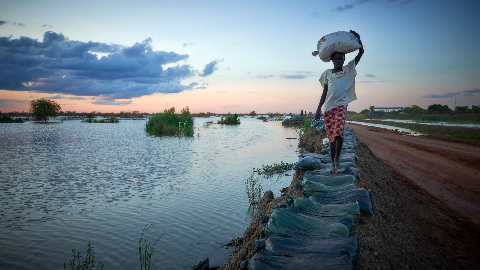 A woman walking along a dye in Bentiu, South Sudan