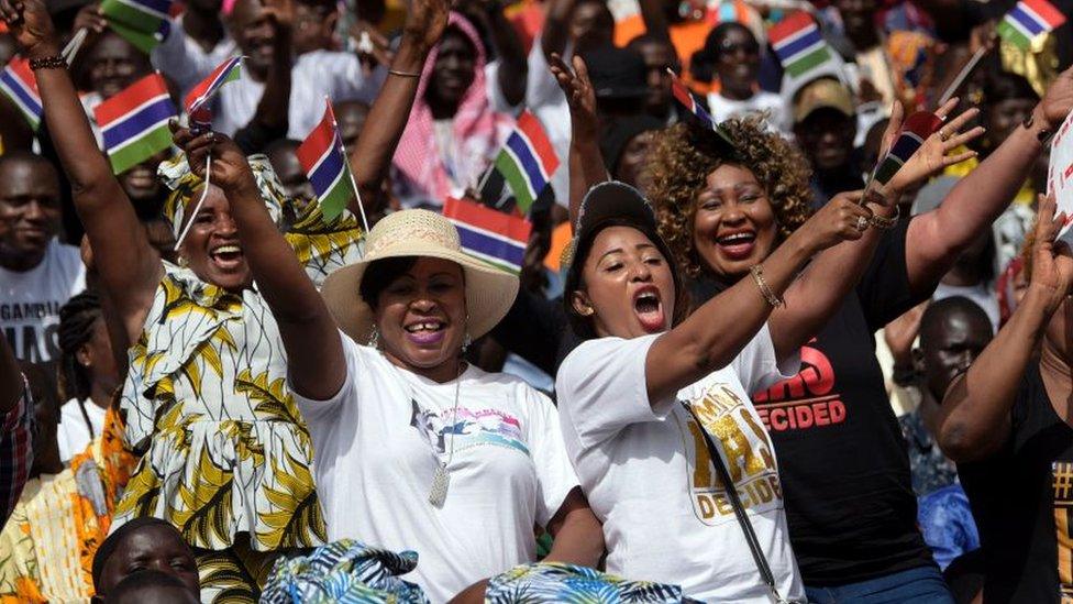 People waving The Gambian flag