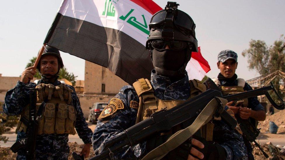 Iraqi federal police officers wave a national flag as they celebrate in Mosul's Old City on 9 July 2017