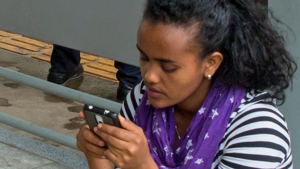 A woman looking at her phone in Ethiopia