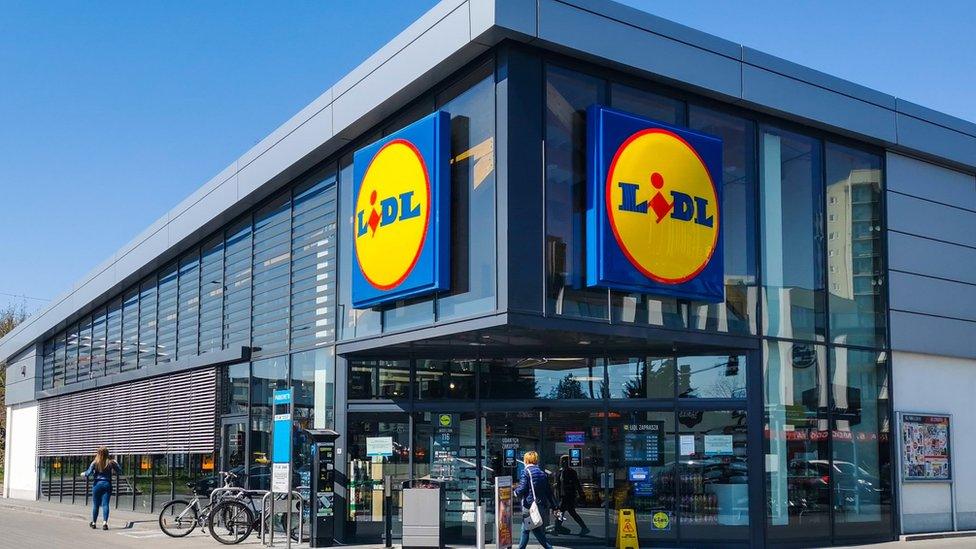 Large Lidl store with bikes outside and customers walking in