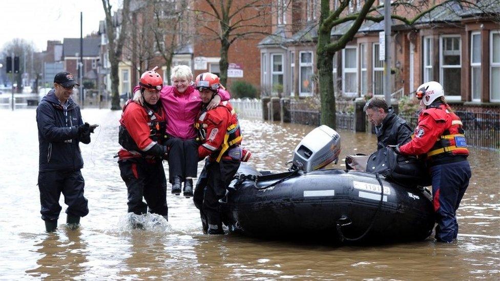 Rescue workers carry people from flooded homes in Carlisle