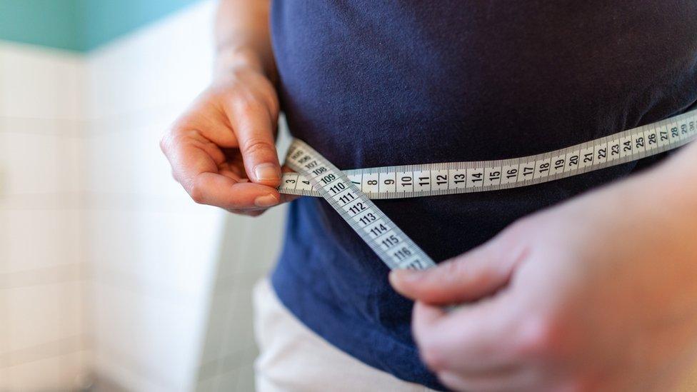 A man measuring his waist