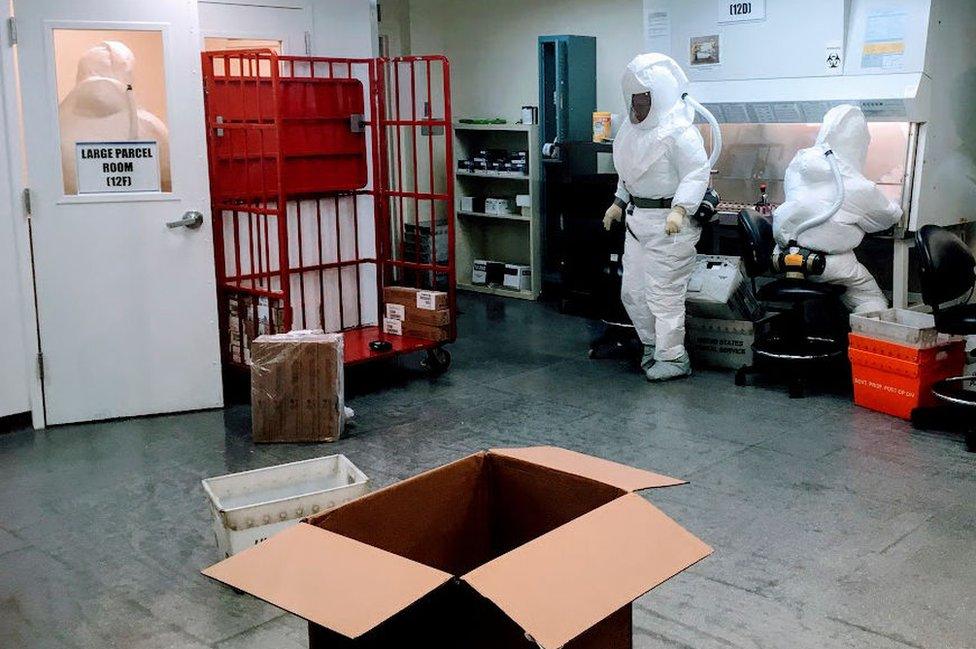 Pentagon officials wear protective suits as they inspect the quarantined mailroom