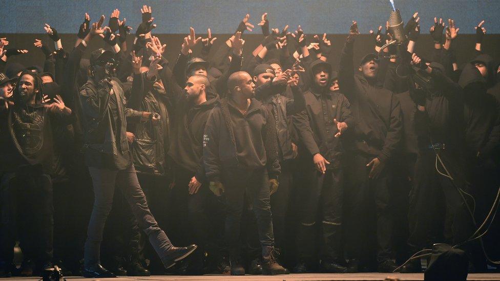 Kanye West on stage at the Brits with grime artists behind him