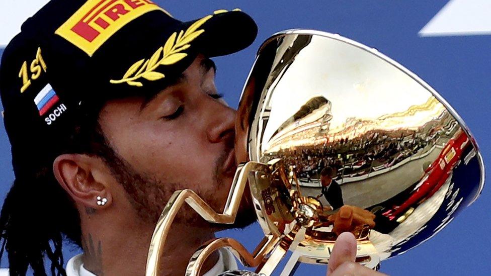 Lewis Hamilton kisses trophy