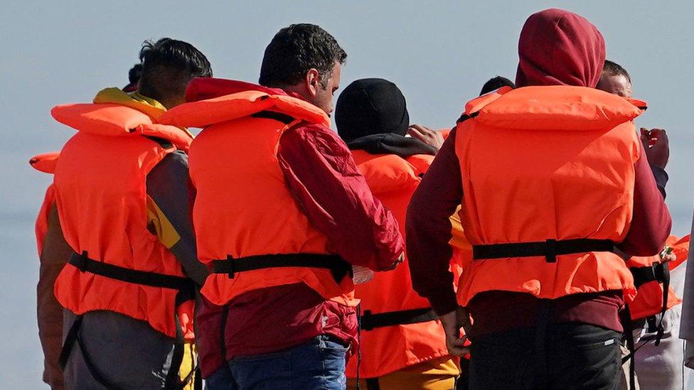 A group of people thought to be migrants on the beach in Dungeness, Kent, after being rescued in the Channel by the RNLI following following a small boat incident.