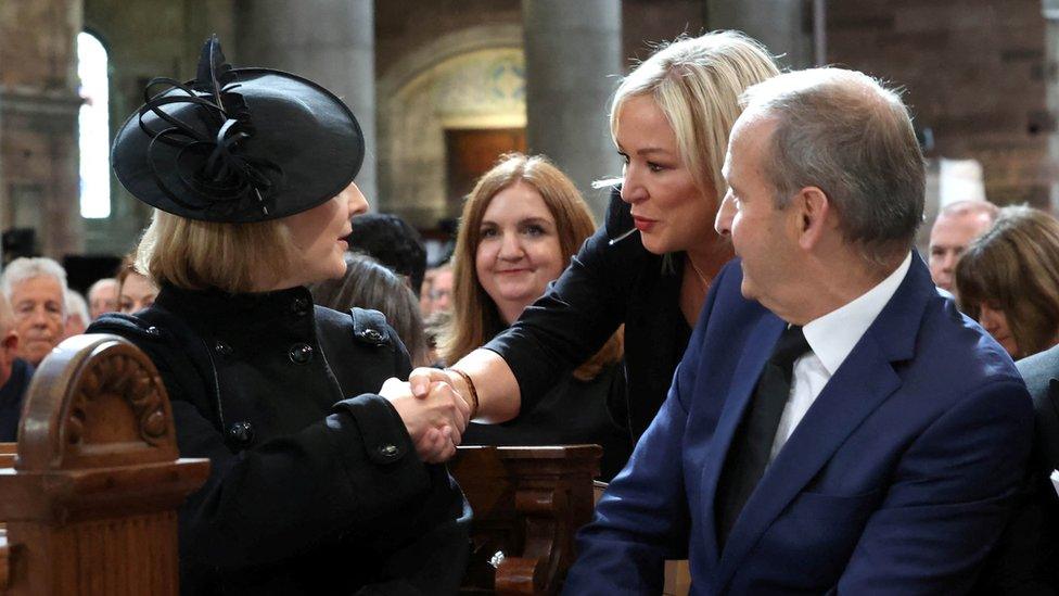 Michelle O'Neill shaking hands with Liz Truss next to Micheal Martin