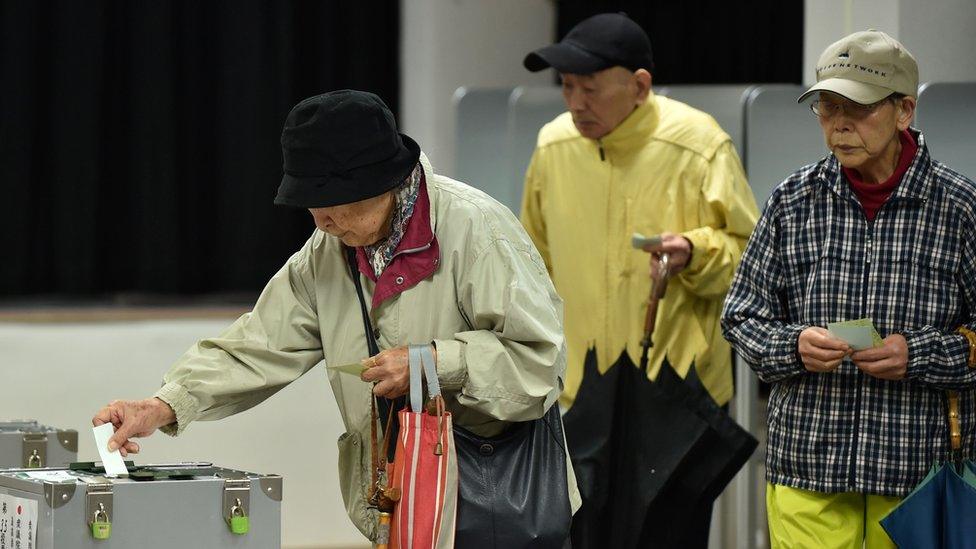 A woman casts her vote in Japan's general election at a polling station in Tokyo on October 22, 2017