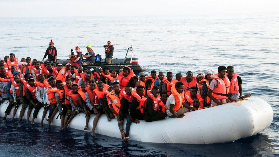 Migrants are seen in a rubber dinghy as they are rescued by the crew of the Mission Lifeline rescue boat in the central Mediterranean Sea, 22 June 2018