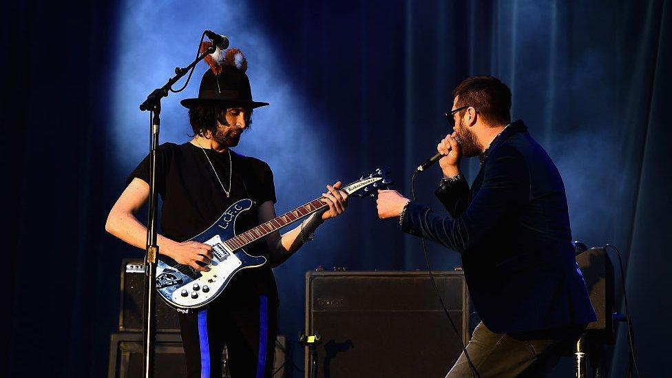 Kasabian performing on stage