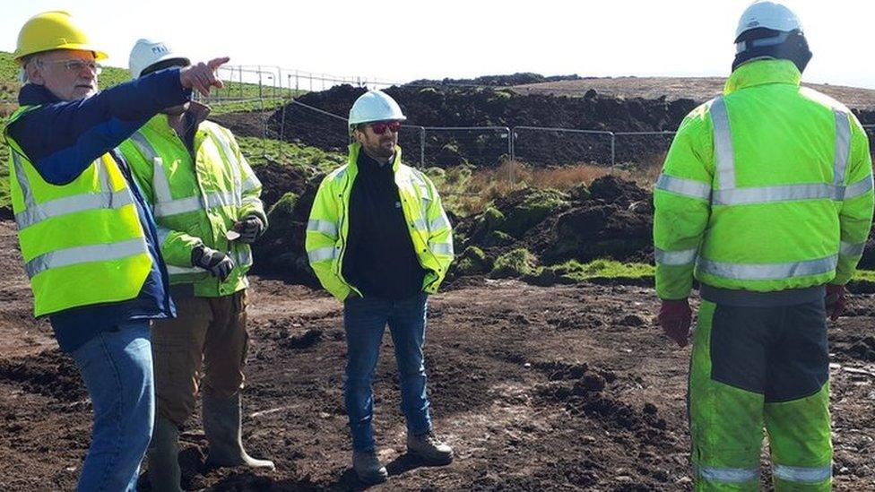 Archaeologists standing round cist