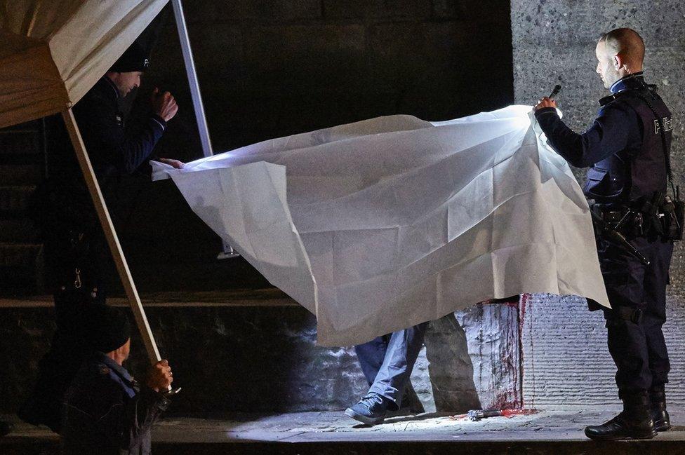 Police cover the body of a gunman at the Gessner bridge in Zurich (19 Dec)