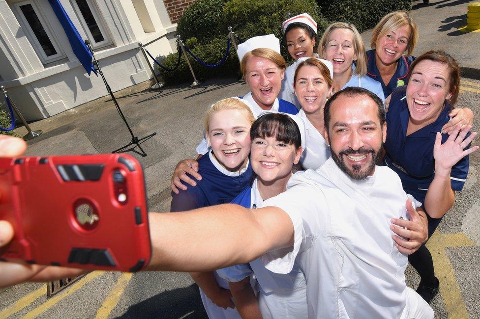 Nurses in uniforms take a selfie photo outside Trafford Hospital