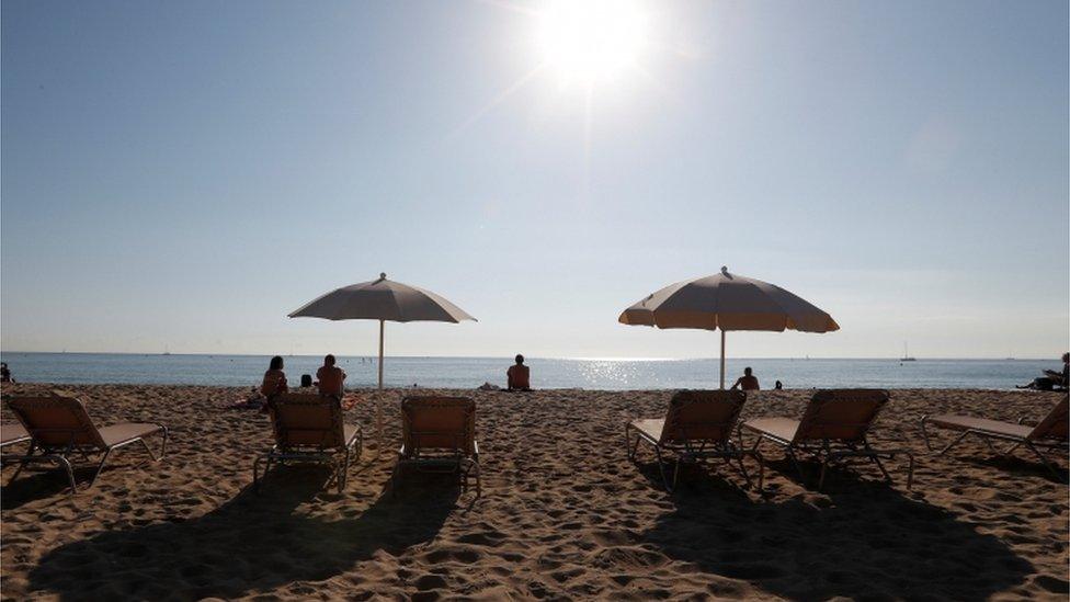 People sunbathe on a hot day in Barcelona, Spain, 15 October 2017