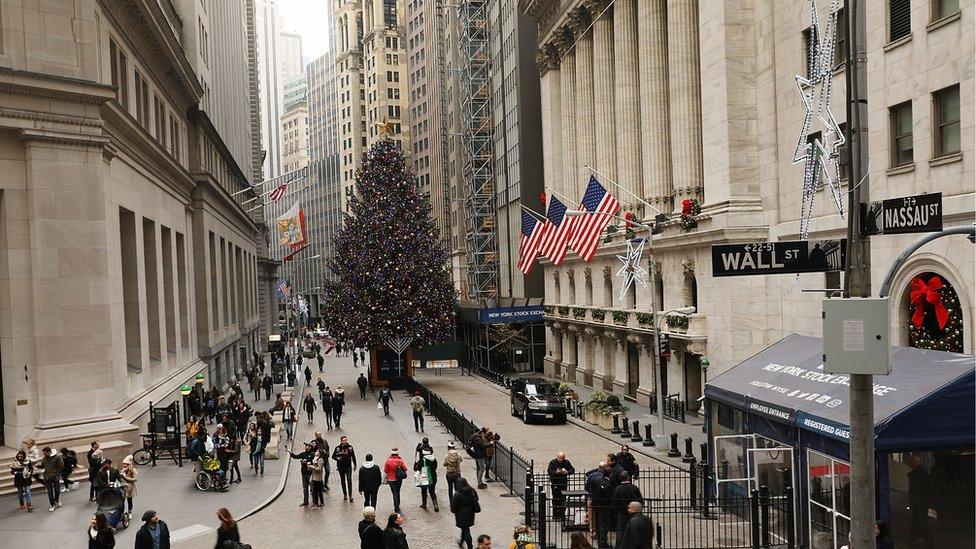 People walk in front of the New York Stock Exchange