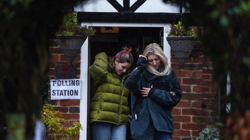 Two people leave a polling station