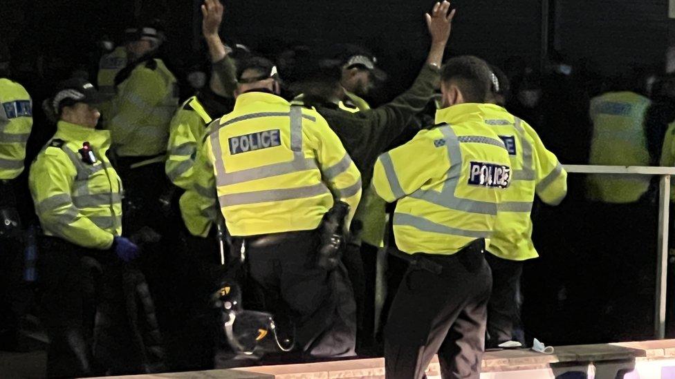 Leicester police stand around man holding his hands in the air