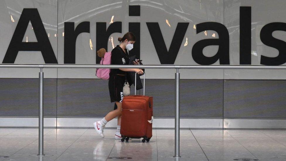 Woman at Arrivals in Heathrow Airport.