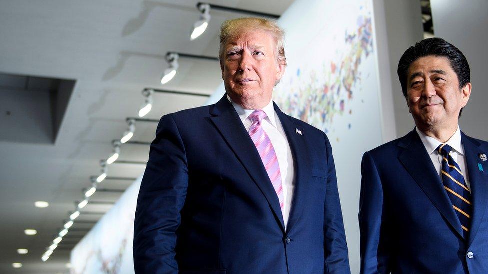 Japan's Prime Minister Shinzo Abe (R) greets US President Donald Trump as he arrives for the G20 Summit in Osaka on June 28, 2019