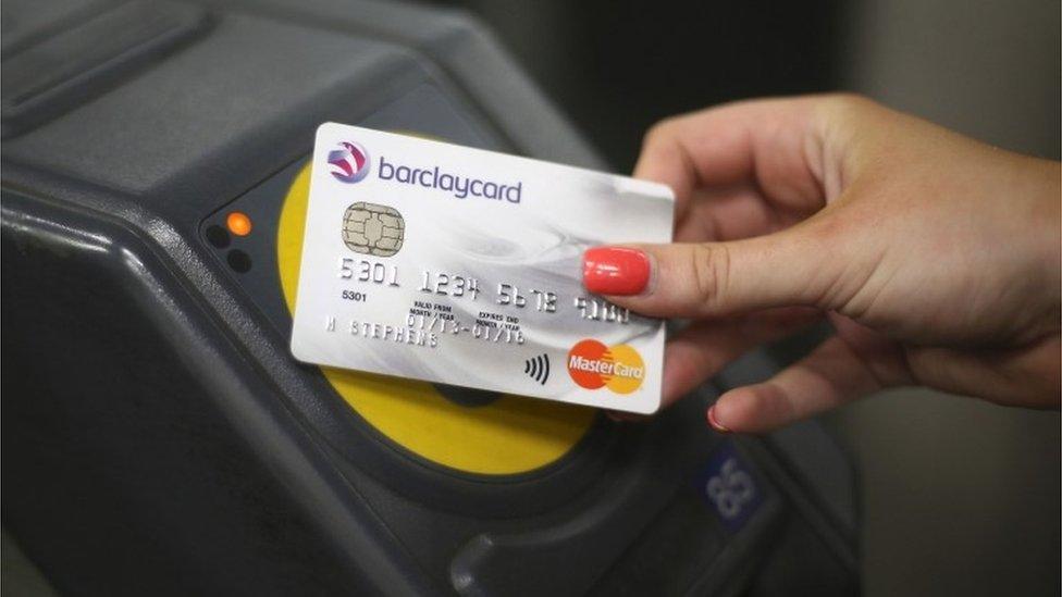 A credit card is tapped on a ticket gate terminal