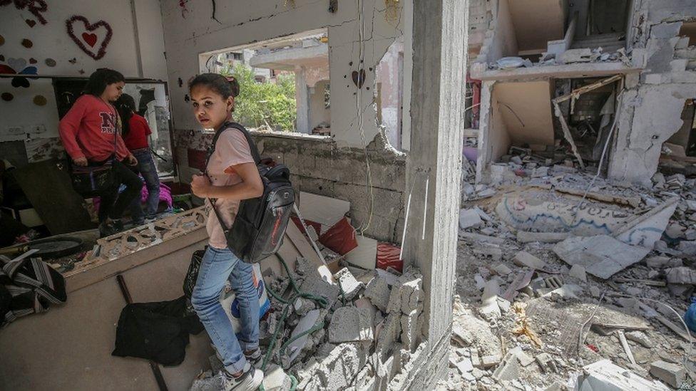 Palestinian girls inspect a destroyed house in Gaza