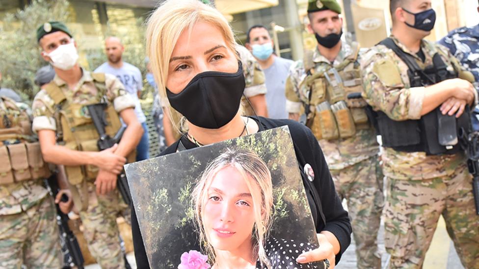 Woman holds picture of person killed in Beirut port explosion (file photo)