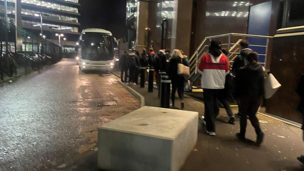 passengers wiating for hte bus in the dark