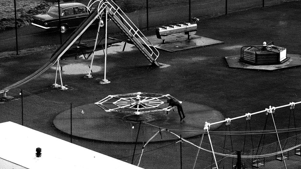 Bachgen yn chwarae ar ei ben ei hun mewn maes chwarae yn Aberfan rhai wythnosau wedi'r gyflafan // A generation wiped out: American photographer Chuck Rapoport took this photo of a lonely young boy on a merry-go-round in Aberfan weeks after the disaster