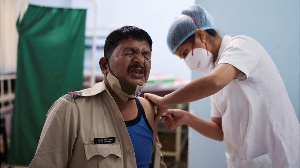 A policeman reacts as he receives a booster dose of the COVISHIELD vaccine against the coronavirus disease (COVID-19), manufactured by Serum Institute of India, at a vaccination centre in Mumbai, India, January 10,