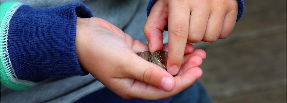 child's hands holding coins