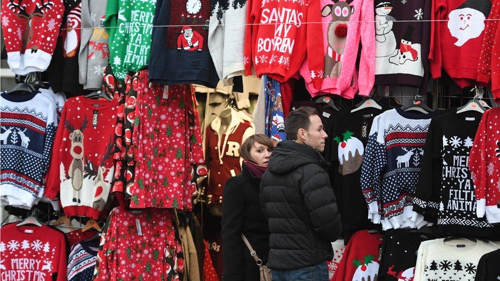 A general view of people looking at Christmas jumpers at a market stall